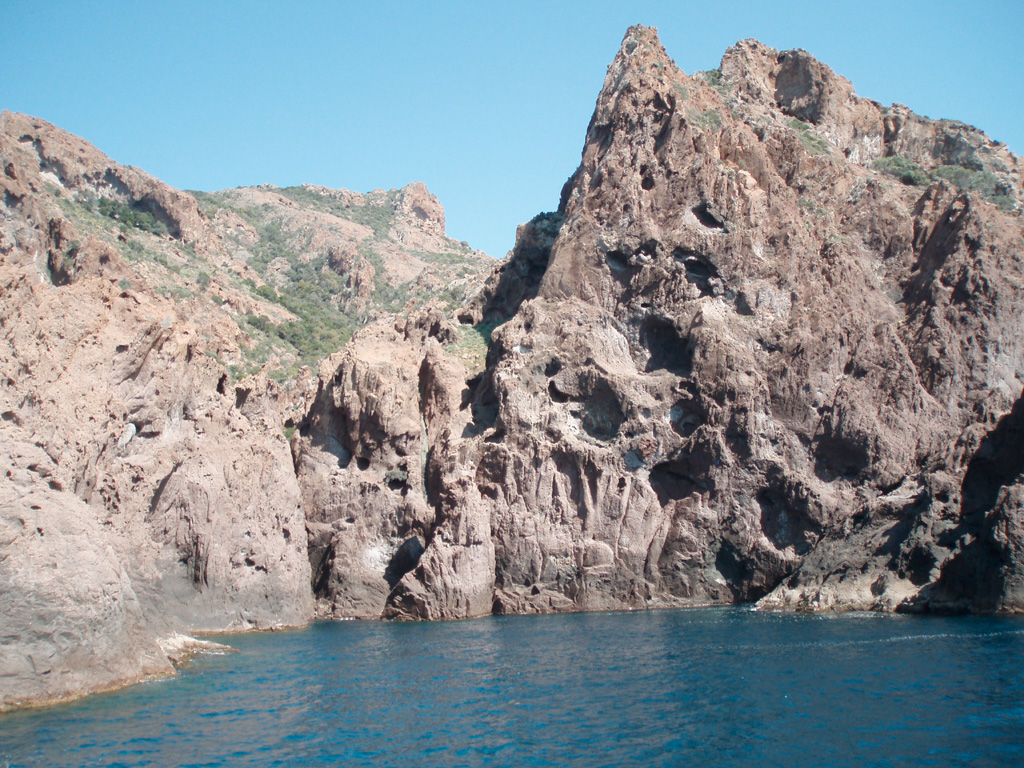 Falaises, aiguilles de granite rouge sculptées par l'érosion. Les cavités "taffoni" qui   perforent les falaises servent de refuge aux oiseaux (cormoran huppé). Réserve de Scandola en Corse entre Galéria et Porto : classée au patrimoine mondial de l'UNESCO.