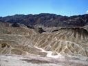 Death Valley (endroit le plus chaud de la planète). La vallée de la mort est un long bassin de 68 km de long et de 8 km de large.
L'histoire géologique des collines et montagnes de Zabriskie Point est impressionnante. Les plus vieilles roches datent de 1,7 milliard d'années, on les trouve dans les Black Mountains à l'arrière plan de la photographie. Au cours de cette longue histoire géologique, la mer s'est retirée, les plaques se sont soulevées, écartées et les failles et l'érosion ont façonné ces magnifiques paysages. Le fond du bassin est recouvert de 3 km de sédiments et de cristaux de sel, le borate (tétraborate de potassium) est une substance naturelle produite par l'évaporation répétée des lacs saisonniers, il est utilisé dans l'industrie des savons et lessives.  [25326 views]
