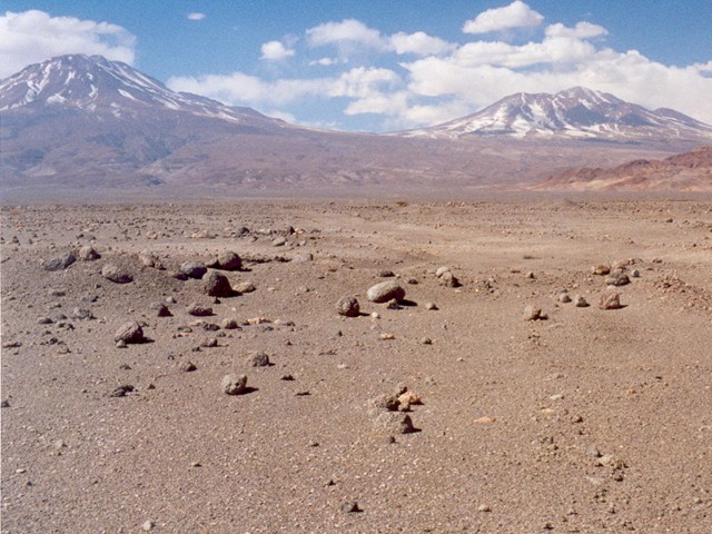 Désert d'Atacama, altitude 2500 m. L'humidité est en moyenne de 12%. Les montagnes enneigées au fond ont une altitude d'environ 5000 m.