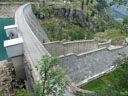 Vue aval du barrage de Campliccioli, situé dans le parc naturel de la haute vallée d'Antrona (Piémont italien). Il s'agit d'un barrage-poids : de section triangulaire, son poids suffit seul à contenir la poussée de l'eau. Il est néanmoins légèrement arqué (rayon de courbure de 600 m). Construit entre 1924 et 1928 en pierres maçonnées, il mesure 80 mètres de haut et 278 mètres de large. Au premier-plan, le déversoir qui permet d'évacuer un éventuel trop-plein. L'eau retenue par le barrage forme un lac, à partir duquel une conduite forcée, c'est-à-dire un assemblage de tuyaux, transporte l'eau sous pression jusqu'à une centrale hydroélectrique située en contrebas dans la vallée.<br />
Voir aussi : <a href='https://phototheque.enseigne.ac-lyon.fr/photossql/photos.php?RollID=images&FrameID= barrage_Campliccioli_amont'>vue amont du barrage</a> - <a href='https://phototheque.enseigne.ac-lyon.fr/photossql/photos.php?RollID=images&FrameID= barrage_Campliccioli_rivage'>rivage du lac</a>
 [2521 views]