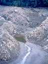 Micaschistes de la série métamorphique du Pilat affleurant dans la retenue du barrage de la Rive.  Leur pendage SSE-NNO est souligné par les niveaux de retrait de l'eau.  Observation de fentes de dessication et d'empreintes d'animaux dans le dépôt de boue argileuse. [27947 views]