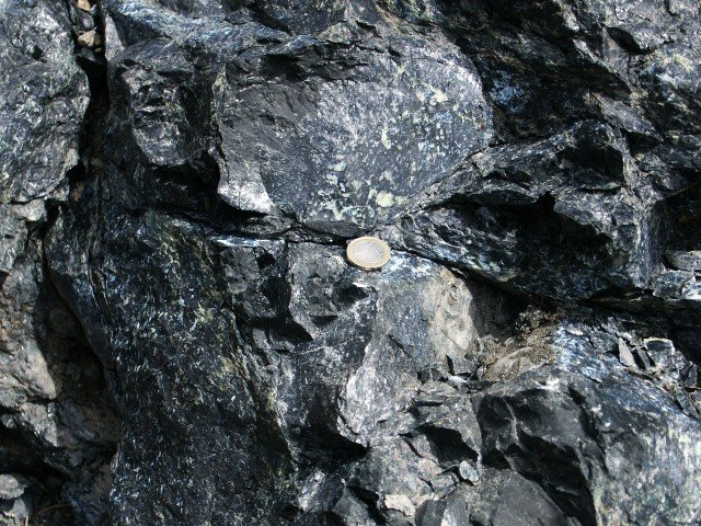 Serpentinite. Péridotite altérée (hydrothermalisme, faible métamorphisme) présentant des minéraux du groupe des serpentines (antigorite, chrysotile).