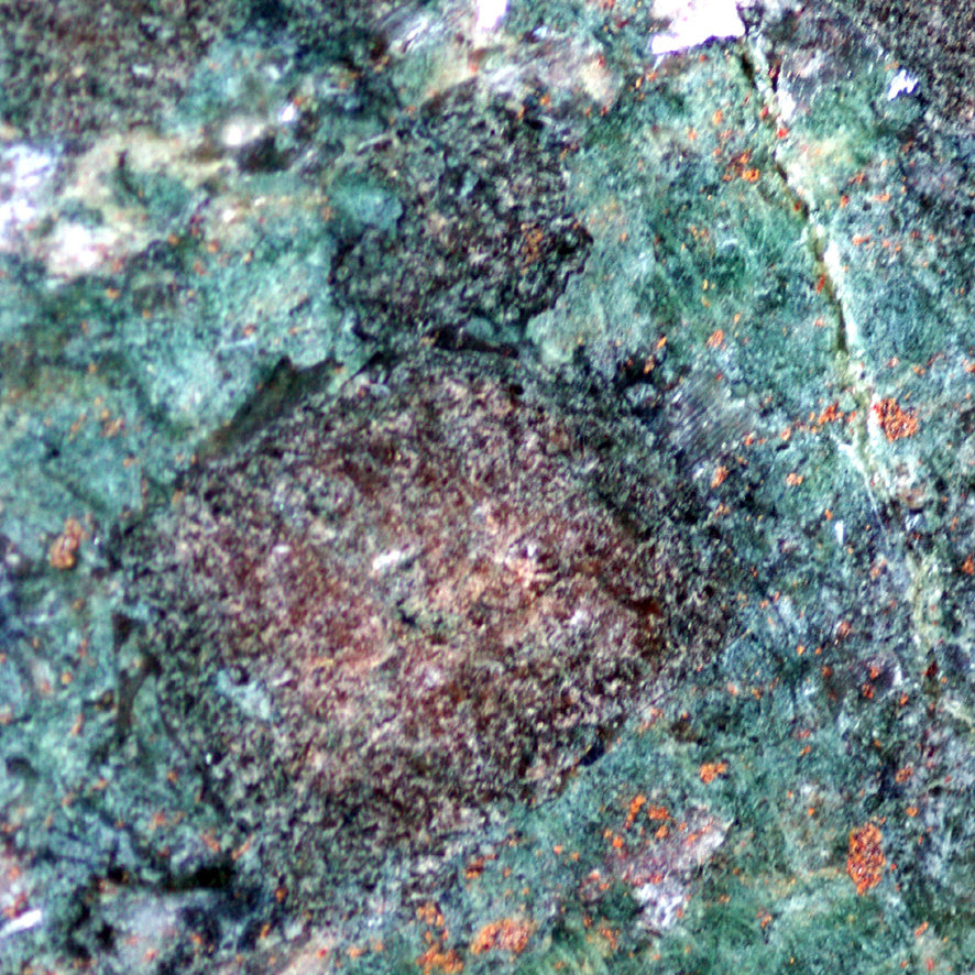 Cette roche est une éclogite à grenat (rose) et jadéite (verte). On peut trouver des traces de plagioclase blanc et d'amphibole (noir-bleu nuit) : la glaucophane. <br /> Cette roche appartient au faciès « éclogite » et, par sa composition, provient de la transformation d'un gabbro. <br /><br />   Cette photographie est proposée dans le cadre d'une évaluation de la quantité d'eau contenue dans la roche (depuis le gabbro de dorsale jusqu'à l'éclogite) par l'utilisation du logiciel Mesurim.  <a href='https://svt.enseigne.ac-lyon.fr/spip/spip.php?article392'>Lien avec le dossier pédagogique</a>.<br /><br />    Mots clefs : métagabbro - éclogite - mesurim -  lithosphère - subduction - plagioclase - glaucophane - grenat - jadéite