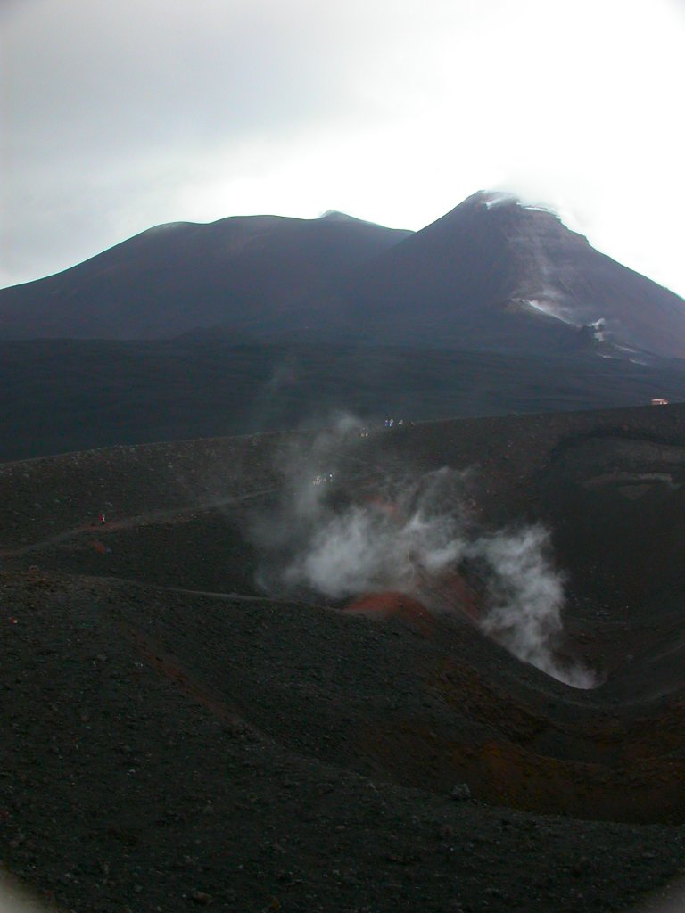 L'Etna est l'un des volcans les plus actifs au monde. Cette vue montre en arrière plan le cratère central (composé des cratères Bocca Nuova (1968) et Voragine(1945)) à gauche et le cratère sud-est (1971) avec ses abondantes fumerolles à droite. Au premier plan, on voit un petit cratère secondaire situé vers 3000 m d'altitude sur le flan sud du volcan.
<BR>
<A HREF='https://phototheque.enseigne.ac-lyon.fr/photossql/GoogleEarth/etna3.kmz'>
<IMG SRC='googleearth.gif' BORDER=0>
</A>