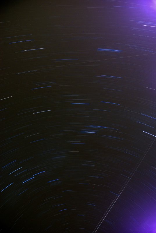 L'objectif de l'appareil étant  dressé vers le ciel nocturne, une pause de 30 minutes est réalisée. Les  étoiles apparaissent sous forme d'arcs de cercles, témoignant de la rotation  de la Terre sur elle même. On peut également voir deux traînées lumineuses  linéaires laissées par des avions.