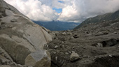 Détail du contact entre le glacier d'Argentière (commune de Chamonix, Haute Savoie) et le substratum rocheux, en amont des <a href='https://phototheque.enseigne.ac-lyon.fr/photossql/photos.php?RollID=images&FrameID=serac_argentiere'>séracs</a>. La glace transporte des éléments détritiques de tailles variées (millimétrique à métrique). Le substratum rocheux a été érodé par le passage du glacier, il apparait poli, moutonné et <a href='https://phototheque.enseigne.ac-lyon.fr/photossql/photos.php?RollID=images&FrameID=stries_glaciaires2'>strié</a>. La prise de vue est orientée vers l'aval.  [5876 views]
