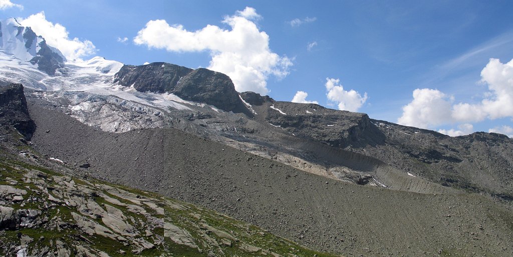 Le glacier de Laveciau depuis le refuge Chabod (Italie, massif du Grand-Paradis). Montage de deux photos. Le glacier prend sa source au pied du Grand-Paradis, à gauche (4061 m). On voit surtout ici sa partie basse, très crevassée, et les moraines latérales et frontale abandonnées par le glacier. Entre les deux moraines latérales, des roches polies. Le pied de la moraine latérale droite est à environ 2700 m.