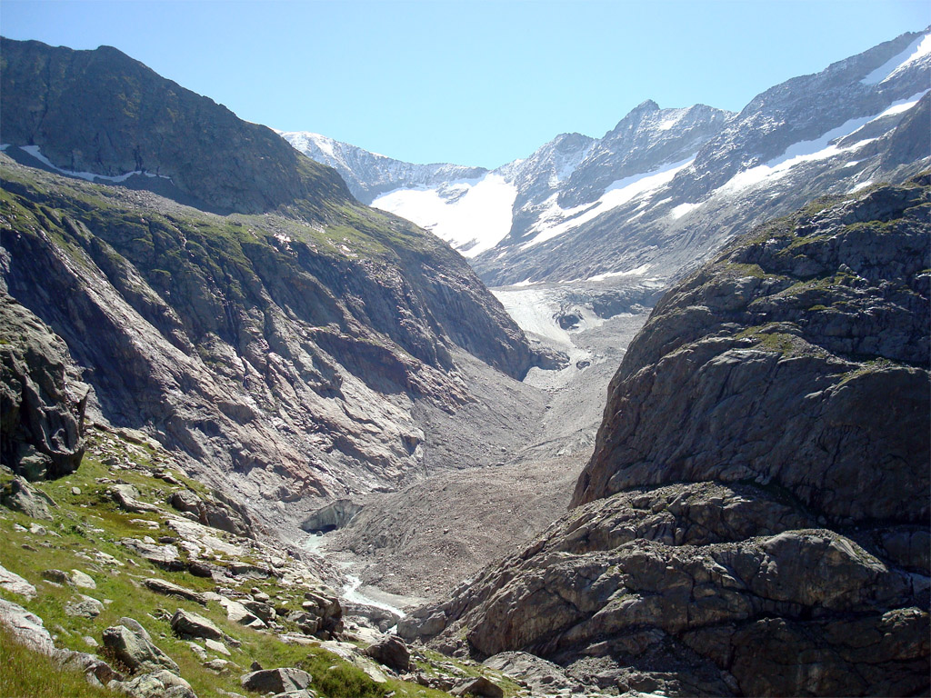 Glacier de Tré la Tête. Le modelé glaciaire est bien visible : vallée en U, avec ses flancs d'auge et ses épaulements, et moraines latérale et frontale. A noter les roches à nu, non encore colonisées par la végétation, qui montrent l'important recul du glacier depuis quelques années.