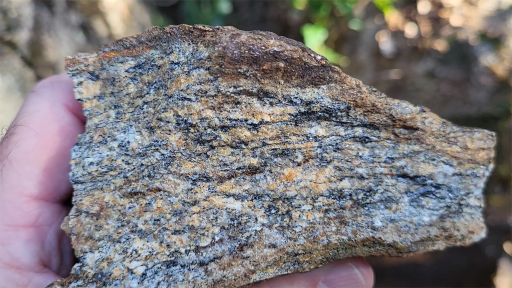 Gneiss à foliation très fine, millimétrique, faite de lits de biotite de très petite taille, alternant avec des lits de quartz automorphes et de microclines xénomorphes.