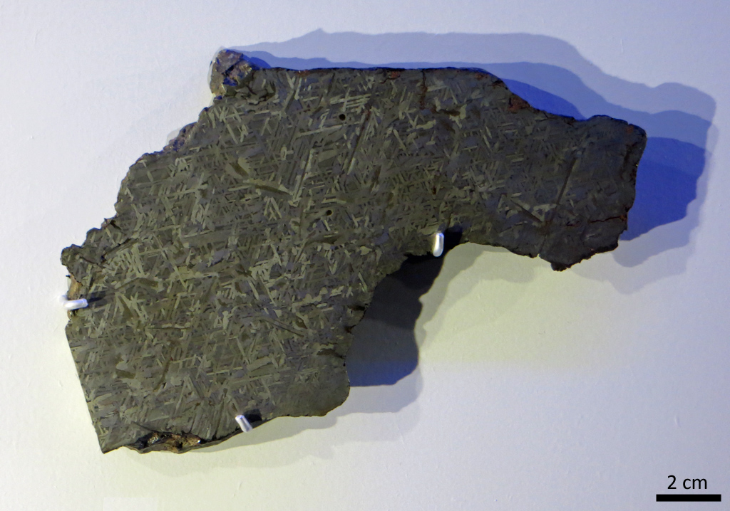 Grant, météorite de fer trouvée en 1929 aux états-Unis. Cette météorite a été coupée, polie, puis exposée à de l'acide nitrique. Ce traitement révèle des figures géométriques, les figures de Widmanstätten, caractéristiques du fer extraterrestre. Elles ne peuvent être produites que si le fer se refroidit extrêmement lentement, en plusieurs millions d'années.  Elles sont une signature unique de la matière extraterrestre. La largeur des motifs permet d'estimer la taille de l'astéroïde dont la météorite provient.