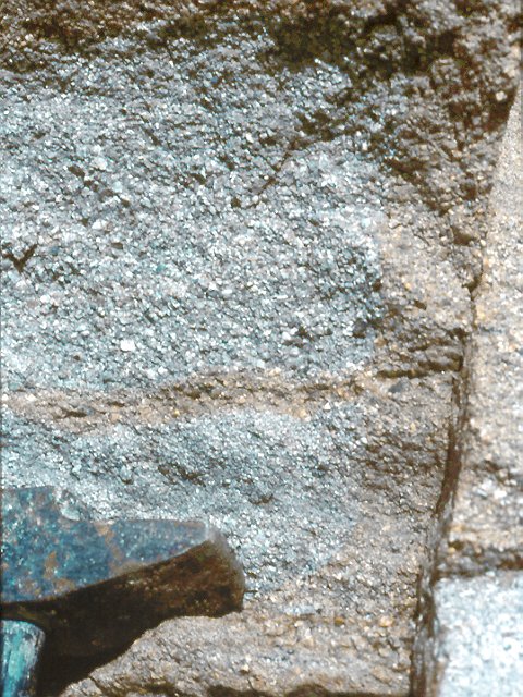 Grès détail. Dans le bassin houiller de Saint-Etienne, le grès sain est de couleur grisâtre. Son altération au niveau de diaclases (circulation d'eau) lui donne une couleur beige orangé.