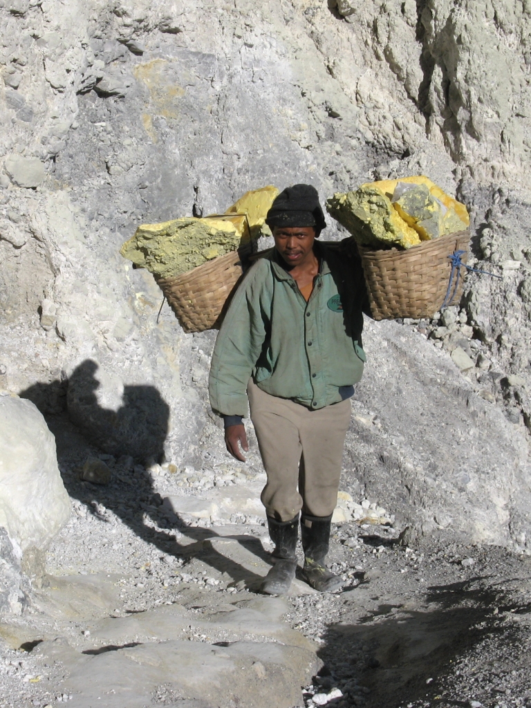 Exploitation du soufre dans le cratère du volcan Ijen. Le soufre, récolté par des ramasseurs, est emporté par des porteurs dont les paniers pèsent jusqu'à 80 kg.