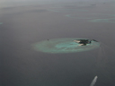 Au premier plan, atoll avec une partie émergée (île). On peut remarquer les constructions destinées à limiter l'érosion des plages. Au second plan, atolls immergés, seule la ceinture de corail est visible.  [22746 views]
