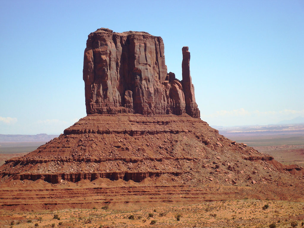 Monument Valley appartient au plateau du Colorado à cheval entre l'état de L'Utah et l'état de l'Arizona. C'est un site protégé administré par les Indiens Navajos. C'est un grand plateau érodé où ne subsiste que des buttes témoins montrant des alternances de schistes et de grès et des limons. Les couleurs vives de la roche proviennent des oxydes de fer et de manganèse. Voir aussi <a href='https://phototheque.enseigne.ac-lyon.fr/photossql/photos.php?RollID=images&FrameID=monument_valley3'>affleurement</a> et <a href='https://phototheque.enseigne.ac-lyon.fr/photossql/photos.php?RollID=images&FrameID=monument_valley1'>paysage 2</a>.