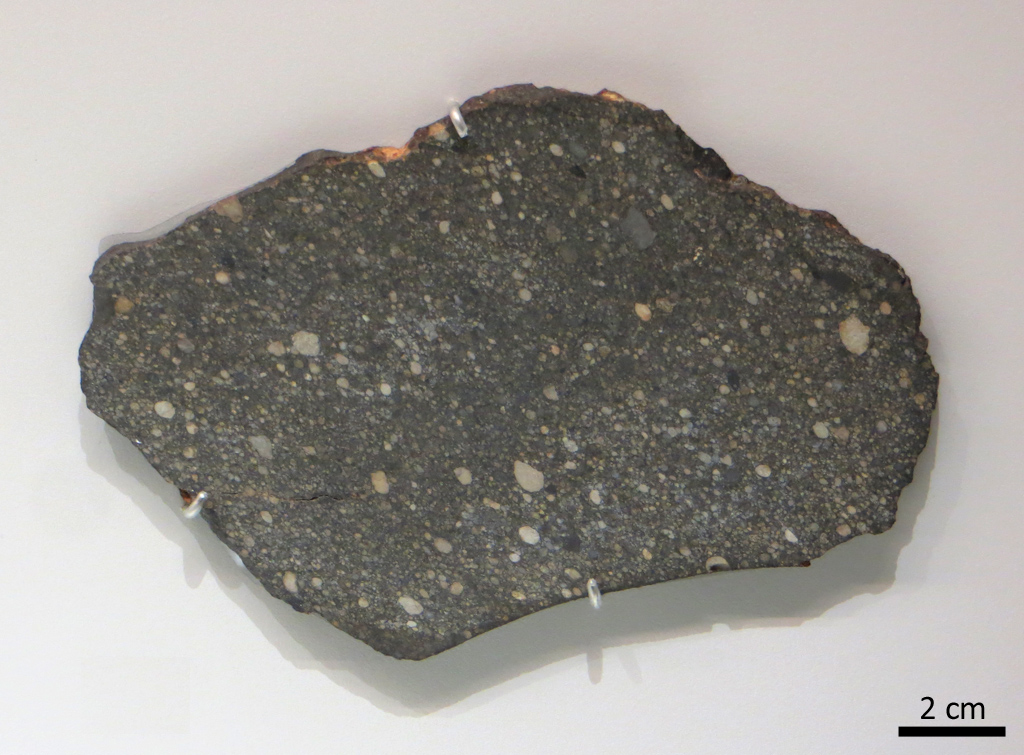 North West Africa 487, chondrite ordinaire tombée en 2000 au Nord-Ouest de l'Afrique. Il n'est pas toujours facile de repérer les chondres au sein des météorites : ces billes de roche fondue et rapidement cristallisée ont parfois été altérées sur leur corps parent, soit par de fortes chaleurs,  soit par de l'eau qui a circulé. Mais dans NWA487, les chondres sont remarquablement bien préservés.