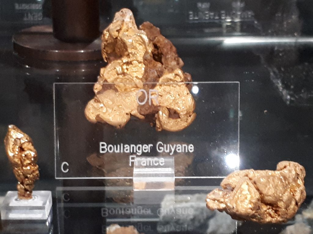 L'or (symbole chimique Au du latin <em>aurum</em>) est un métal précieux malléable et ductile. Il se trouve à l'état natif en paillettes ou sous la forme de masses informes (pépites) prises dans une gangue de quartz et de sulfures métalliques. Les pépites se trouvent dans les filons ou concentrées dans certaines zones d'alluvions (les placers) où l'exploitation se fait par lavage. L'exploitation de l'or en Guyane existe depuis le XIX<sup>è</sup> siècle sous forme d'orpaillage.