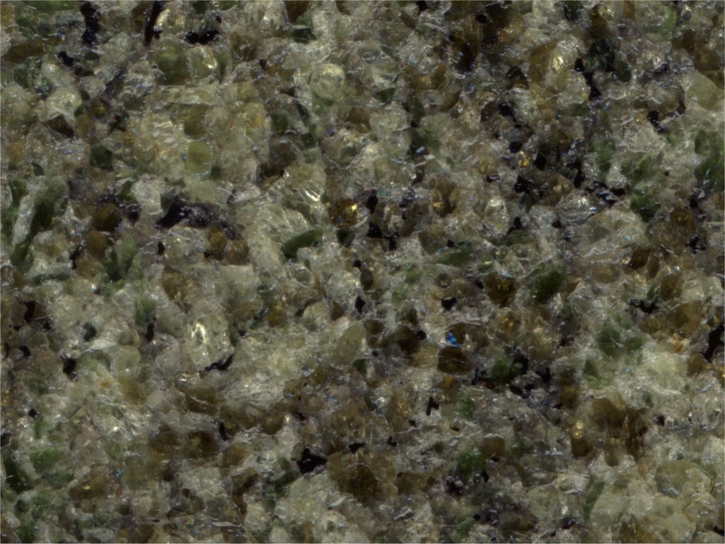 Echantillon de péridotite du Velay, surface polie scannée. On distingue des cristaux d'olivine, et deux catégories de pyroxènes (vert émeraude et brun).