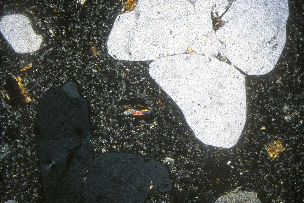 Rhyolite : texture microlithique - de gros critaux corrodés de quartz   sont visibles (un est éteint en bas à gauche)