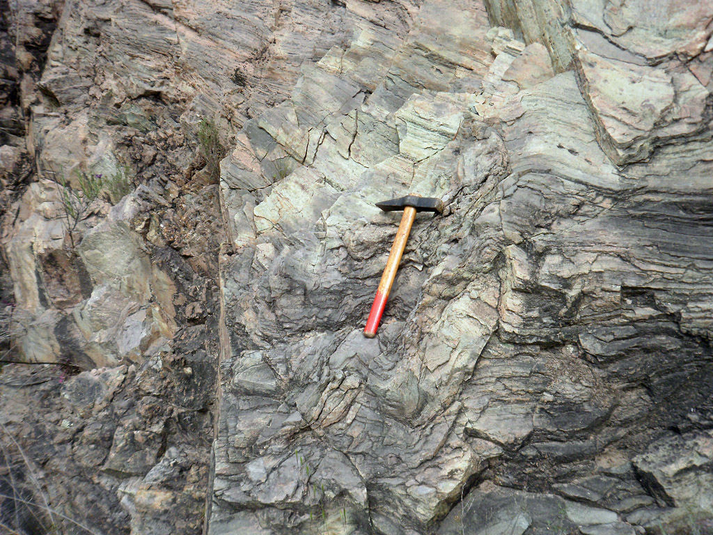 Affleurement type de rhyolite fluidale dans le massif de L'Esterel (248 millions d'années) :  la roche présente une fluidalité millimétrique, qui conduit localement à un débit en plaquettes  et des plis d'écoulement dus à sa mise en place  à l'état visqueux (pâteux), ici sous forme de dôme-coulée.
Voir aussi un <a href='https://phototheque.enseigne.ac-lyon.fr/photossql/photos.php?RollID=images&FrameID=pli'>autre affleurement</a> et une image de <a href='https://phototheque.enseigne.ac-lyon.fr/photossql/photos.php?RollID=images&FrameID=rhyolite_fluidale_spherolitique'>lame mince en microscopie</a>.