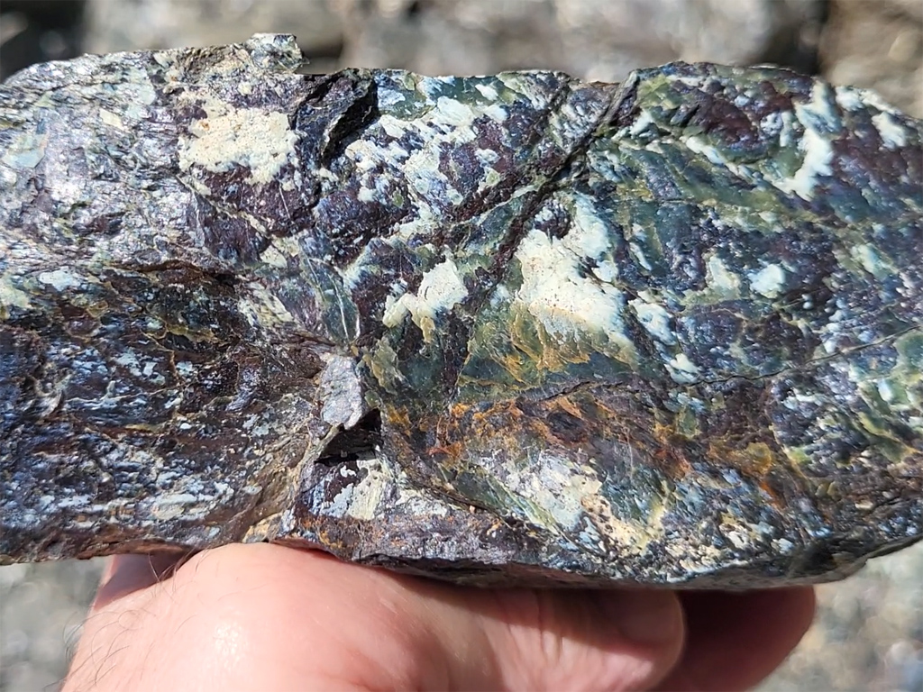 Affleurement de serpentinite. Il s’agit de phyllosilicates résultant de l’hydratation des olivines (et accessoirement des pyroxènes) des péridotites. Ce sont donc les produits du métamorphisme du manteau. Les formes les plus courantes de serpentinites sont vertes à blanches ou jaunâtre, avec souvent des reflets bleutés. Elles tirent leur nom de leur aspect semblable à celui d'écailles et une sensation particulière au toucher, qui peut évoquer la peau d'un serpent. Ces roches se trouvent généralement dans des chaines de montagnes, anciennes ou récentes, qui ont amené à proximité de la surface des parties du manteau terrestre.<br />
<a href= 'https://phototheque.enseigne.ac-lyon.fr/photossql/photos.php?RollID=images&FrameID=serpentinite_gavignano1'>Vue d’ensemble de l’affleurement</a> – <a href='https://phototheque.enseigne.ac-lyon.fr/photossql/photos.php?RollID=images&FrameID=serpentinite_gavignano2'> Vue rapprochée 1</a> – <a href='https://phototheque.enseigne.ac-lyon.fr/photossql/photos.php?RollID=images&FrameID=serpentinite_gavignano3'> Vue rapprochée 2</a> – Échantillon 1 – <a href='https://phototheque.enseigne.ac-lyon.fr/photossql/photos.php?RollID=images&FrameID=serpentinite_gavignano5'> Échantillon 2</a>
