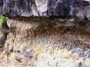 Sill de basalte intercalé entre deux niveaux argileux d'argiles et de sables du Villafranchien. Cette photographie montre le basalte surmontant les argiles rubéfiées (rougies)par la chaleur de la lave intrusive. On distingue aussi une prismation des argiles provoquée par la portée du matériau à haute température suivi de son refroidissement  Mots clefs : sill - basalte - filon - datation relative - volcanisme
<a href='http://svt.enseigne.ac-lyon.fr/spip/spip.php?article153' TARGET='_blank'>Page liée</a> [10749 views]