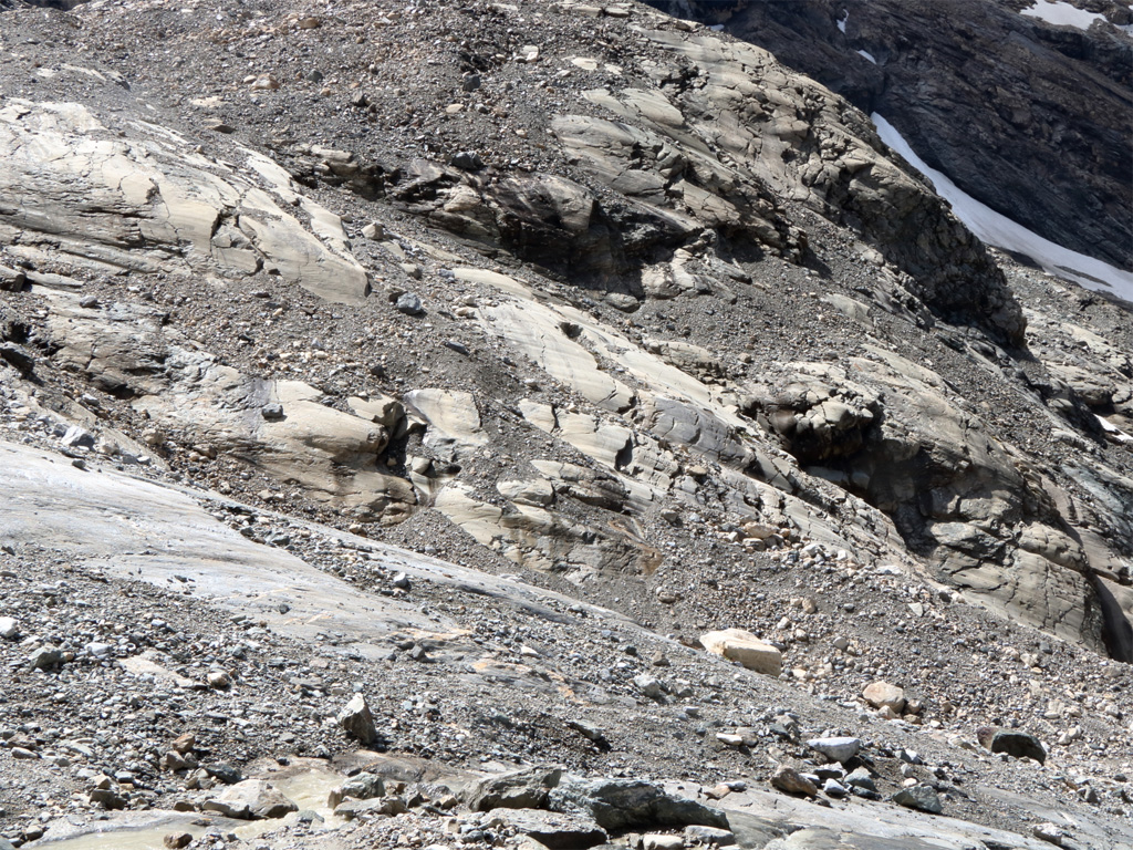 Roches situées en aval du <a href='https://phototheque.enseigne.ac-lyon.fr/photossql/photos.php?RollID=images&FrameID= glacier_Rhemes-Golette
'>glacier de Rhêmes-Golette</a>, au fond de la vallée de la grande Sassière, dans les Alpes. Le recul important du glacier (plus de 300 m durant les cinquante dernières années) met à l'affleurement les roches qui se trouvent normalement sous la glace. On observe ainsi des roches moutonnées : rabotées, arrondies et striées par le passage du glacier et des blocs qu'il charrie.
