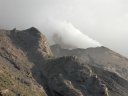 Cratère du Stromboli, dans les îles Eoliennes. Ce volcan présente une intense activité depuis plus de 3 000 ans. Le magma basaltique est très chaud, fluide et assez pauvre en gaz. Lorsque le magma remonte, des bulles se forment par dépressurisation. Les bulles de gaz se séparent spontanément du magma, remontent vers la surface et forment de véritables poches de gaz à quelques mètres sous la surface. Au bout d'un moment, la pression gazeuse devient suffisante pour expulser la colonne de magma qui se trouve au-dessus dans le conduit : c'est ce mécanisme qui est à l'origine des explosions de type strombolien. Les poches de gaz étant séparées les unes des autres, les explosions sont elles-mêmes séparées par des périodes de repos de plusieurs minutes. Le magma éjecté se fragmente en retombant autour du cratère sous forme de projections de taille variable (cendres, lapilli, blocs) qui en s'accumulant construisent les cônes de projections caractéristiques du dynamisme strombolien.
<BR>
<A HREF='https://phototheque.enseigne.ac-lyon.fr/photossql/GoogleEarth/stromboli.kmz'>
<IMG SRC='googleearth.gif' BORDER=0>
</A> [6670 views]