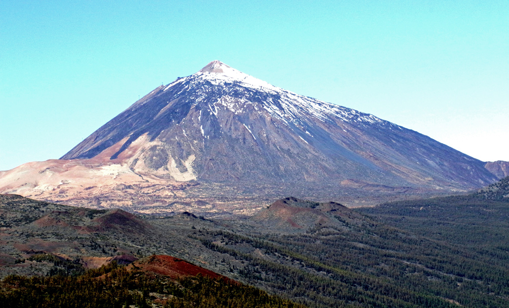 Le pic du Teide est situé sur l'île de Ténérife appartenant aux Canaries. Avec ses 3718 m d'altitude  c'est le point culminant de l'Espagne, et c'est aussi depuis sa base la troisième structure volcanique la plus haute de la planète, après le Mauna Loa et le Mauna Kea situés à Hawaï.  L'Unesco a classé en 2007 le parc national du Teide au patrimoine mondial. Le volcan est situé dans une grande caldeira où l'on observe <a href='https://phototheque.enseigne.ac-lyon.fr/photossql/photos.php?RollID=images&FrameID=coulee_teide'>dykes, necks, coulées</a>. Les dernières éruptions et coulées sont situées près de la Montana Bianca, reconnaissable par sa pierre ponce. 