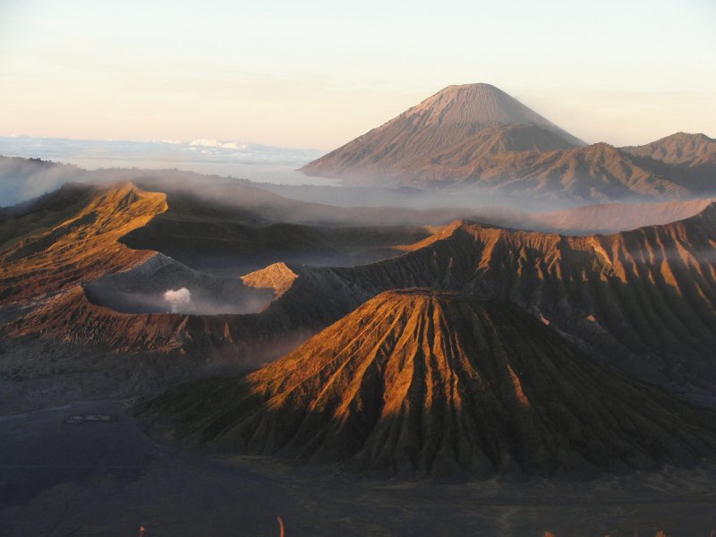 Lever de Soleil sur la caldeira du Tengger. Au premier plan à droite, le Batok, volcan éteint aux flancs ravinés par l'érosion. A gauche, fumant et très actif, le Bromo (2392 m). Au loin, on peut apercevoir le Semeru, point culminant de Java (3676 m) qui développe un panache toutes les 20 minutes. La photo est prise du Penanjakan.
<BR>
<A HREF='https://phototheque.enseigne.ac-lyon.fr/photossql/GoogleEarth/tengger.kmz'>  <IMG SRC='googleearth.gif' BORDER=0> </A>